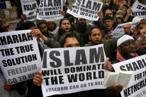 Muslims carrying banners declaring 'Islam will dominate the world' protest at the visit of Mr Wilders to the UK